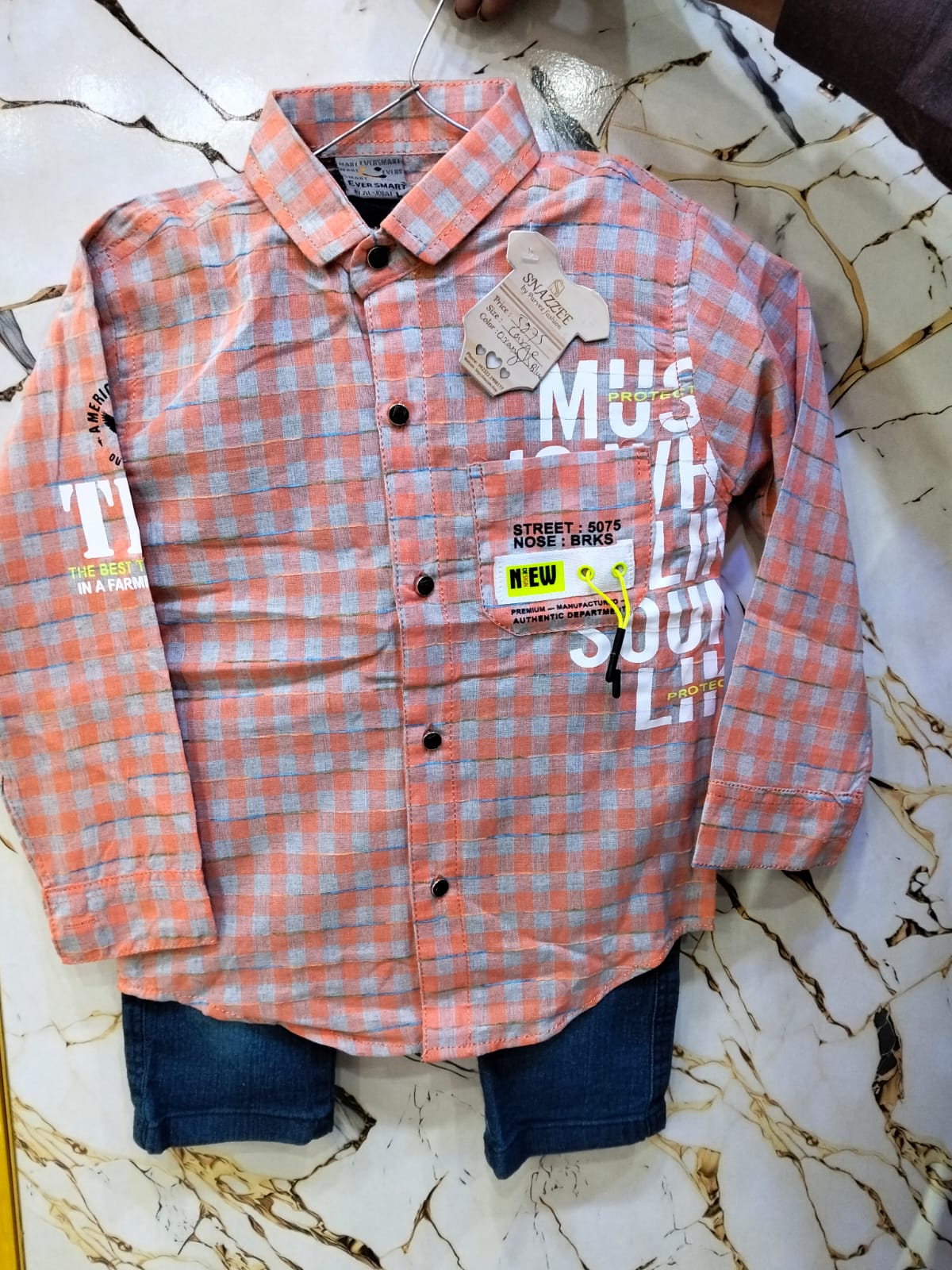 Plaid shirt with visible brand tags on a marble surface