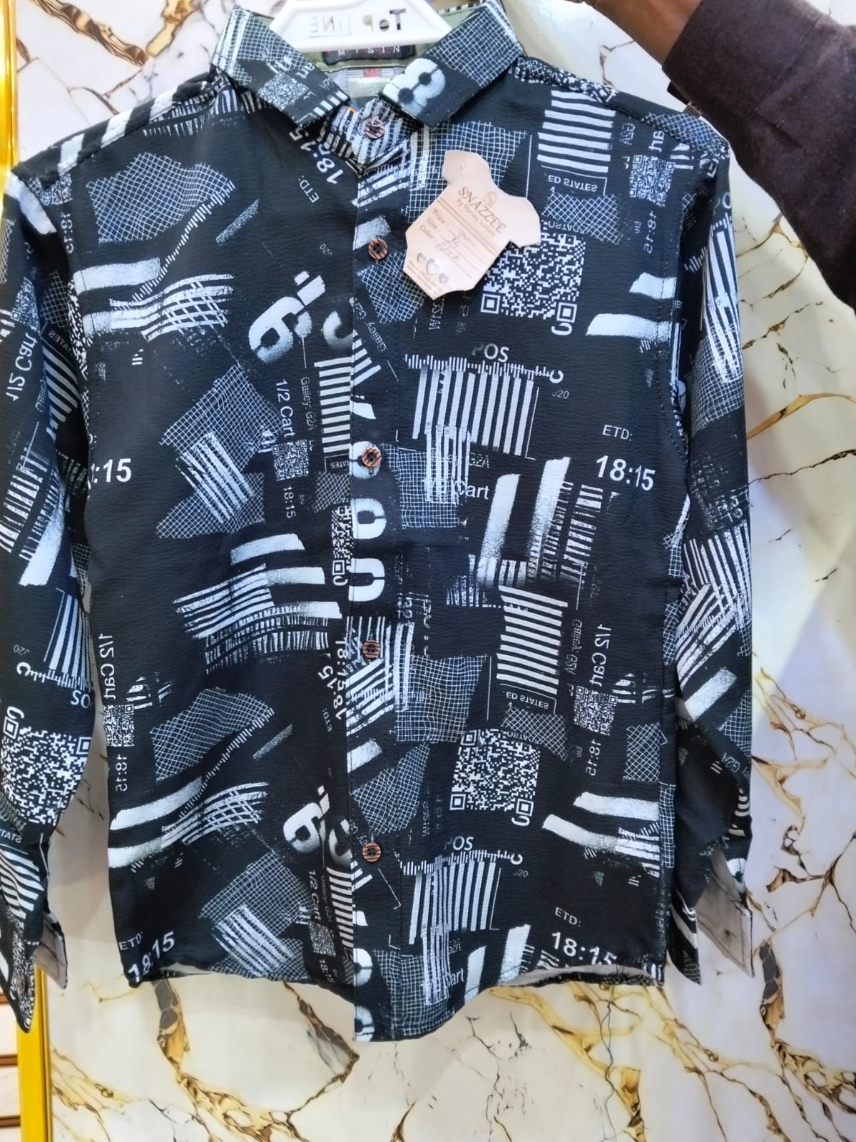 Black shirt with white geometric pattern on a marble surface